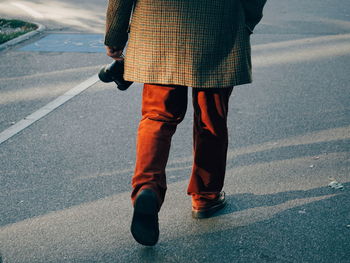 Low section of man walking on road