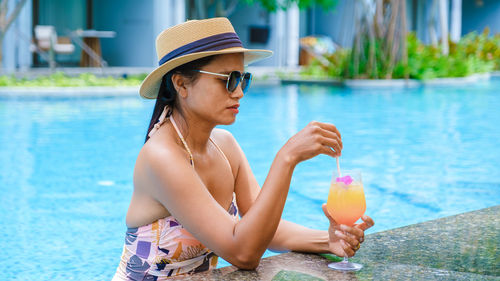 Young woman drinking water in lake