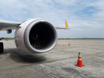 Close-up of airplane on runway against sky