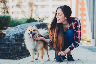 Smiling young woman with dog outdoors