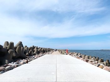 Footpath by sea against sky