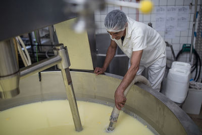 Cheese factory worker controlling curdling process