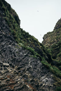 Low angle view of rocks on mountain against sky