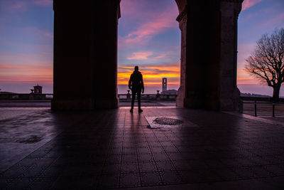 Rear view of silhouette man standing against sky during sunset