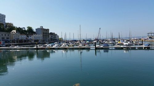 Boats in calm sea with buildings in background