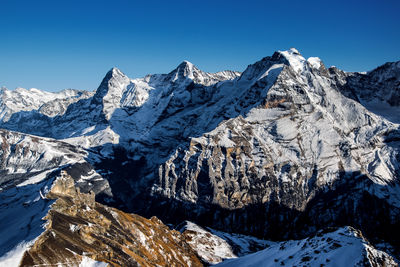 Scenic view of snowcapped mountains against clear sky