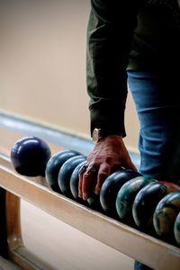 Midsection of man holding bowling ball