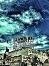 Low angle view of buildings against cloudy sky