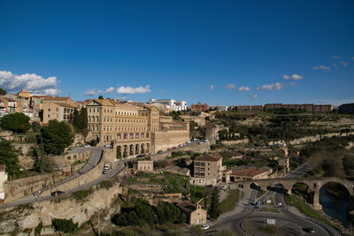 High angle view of buildings in city against blue sky