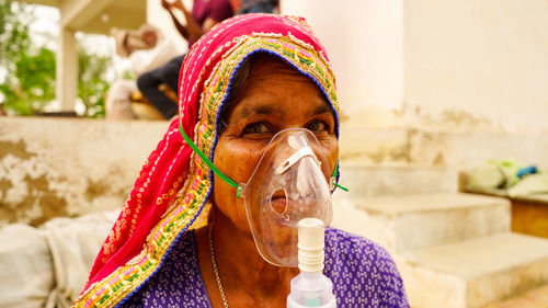 Indian old woman infected with covid 19 disease. patient inhaling oxygen wearing mask with liquid ox