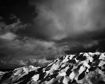 Scenic view of snowcapped mountains against dramatic sky