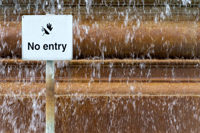 Close-up of text on wet wood during winter