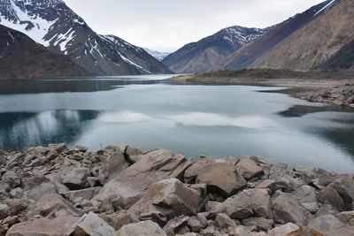 Scenic view of lake by mountains against sky