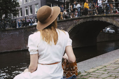 Woman in white dress overlooking canal and crowds