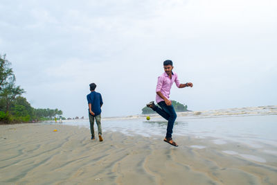 Friends playing on sand at beach