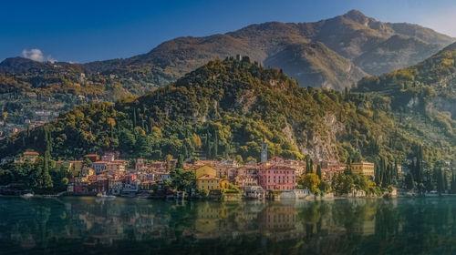 Scenic view of lake by buildings against mountains