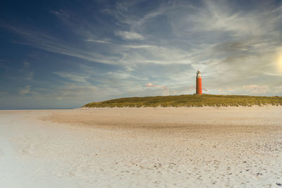 Lighthouse by sea against sky