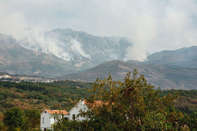 Scenic view of mountains and buildings against sky