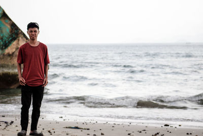 Portrait of young man standing at beach