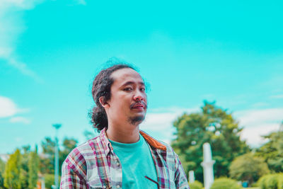 Low angle view of young man against sky