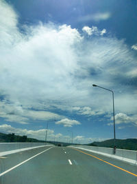 Empty road against cloudy sky