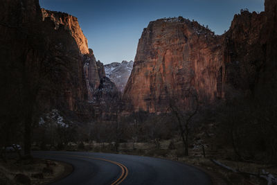 Road amidst rocky mountains against sky