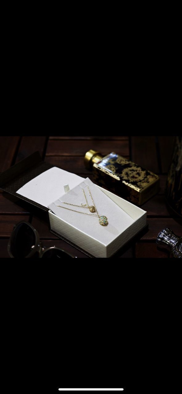 HIGH ANGLE VIEW OF WEDDING RINGS ON TABLE WITH PAPER