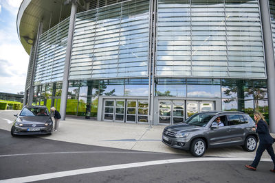 Cars parked on road by building in city