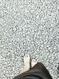 Low section of woman standing on stones