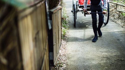 Low section of man walking on footpath in city