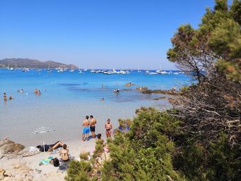 High angle view of people on shore at beach against blue sky