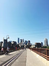 Road against clear blue sky in city