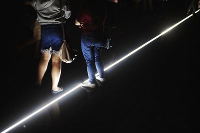 Low section of people standing on illuminated stage