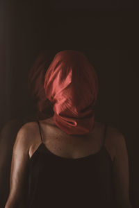 Portrait of woman with red hair against black background