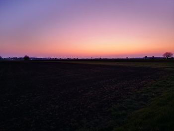 Scenic view of field against clear sky during sunset