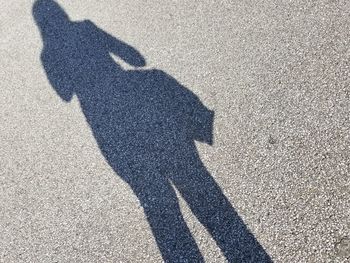 Shadow of woman falling on road