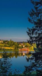 Scenic view of calm lake against clear blue sky