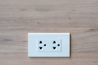 Close-up of electrical outlet on wooden wall