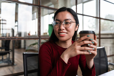 Portrait of young woman drinking drink