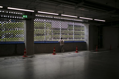 Rear view of man standing by window in basement