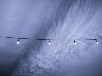 Low angle view of light bulbs against sky