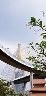Low angle view of bridge by building against clear sky