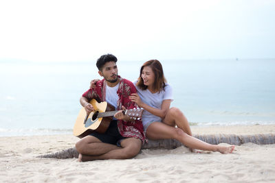 Young couple sitting on beach