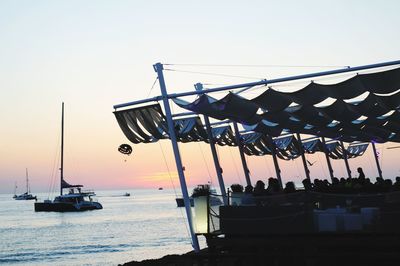 Boats in sea at sunset