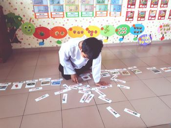 Full length of boy playing on tiled floor