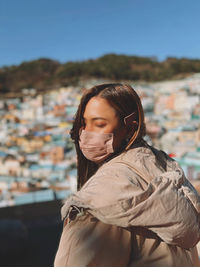 Side view of woman looking away against sky