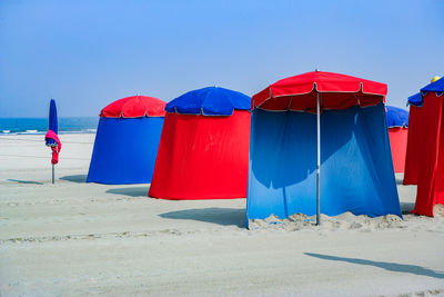 Multi colored umbrellas on beach against clear blue sky
