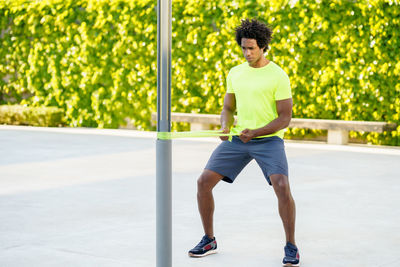 Full length of young man sitting on wall