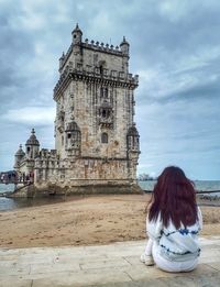 Woman with historic building against sky