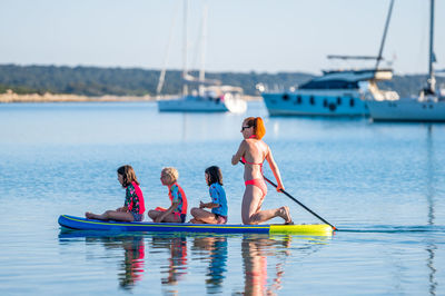 Full length of father and daughter on boat in water